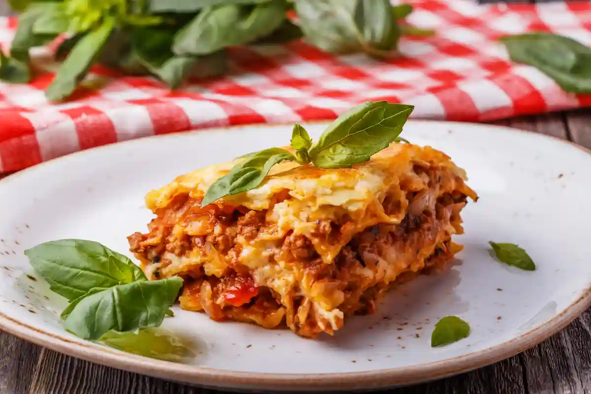 Receita completa de lasanha à bolonhesa caseira, com história, ingredientes simples, modo de preparo detalhado, dicas, variações, conservação e valor nutricional.