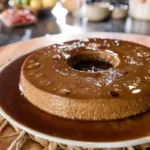 Pudim de café cremoso feito no liquidificador, assado em banho-maria e servido gelado com uma calda dourada de caramelo.